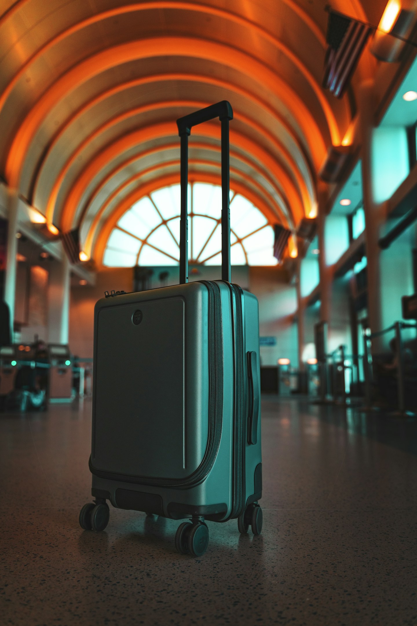 Travel luggage beside an airport window